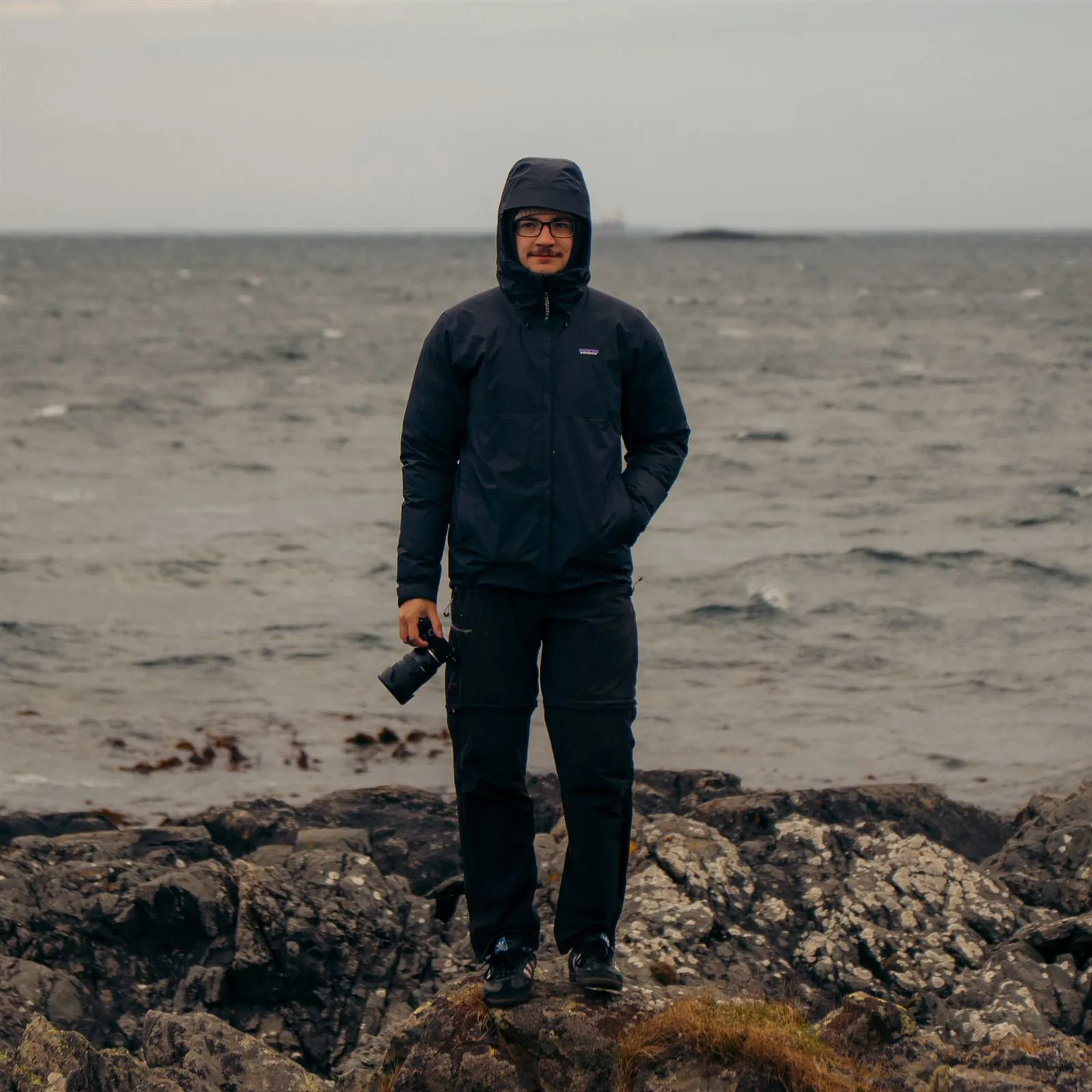 Jan Tomášek with a camera on a rocky shore by the sea